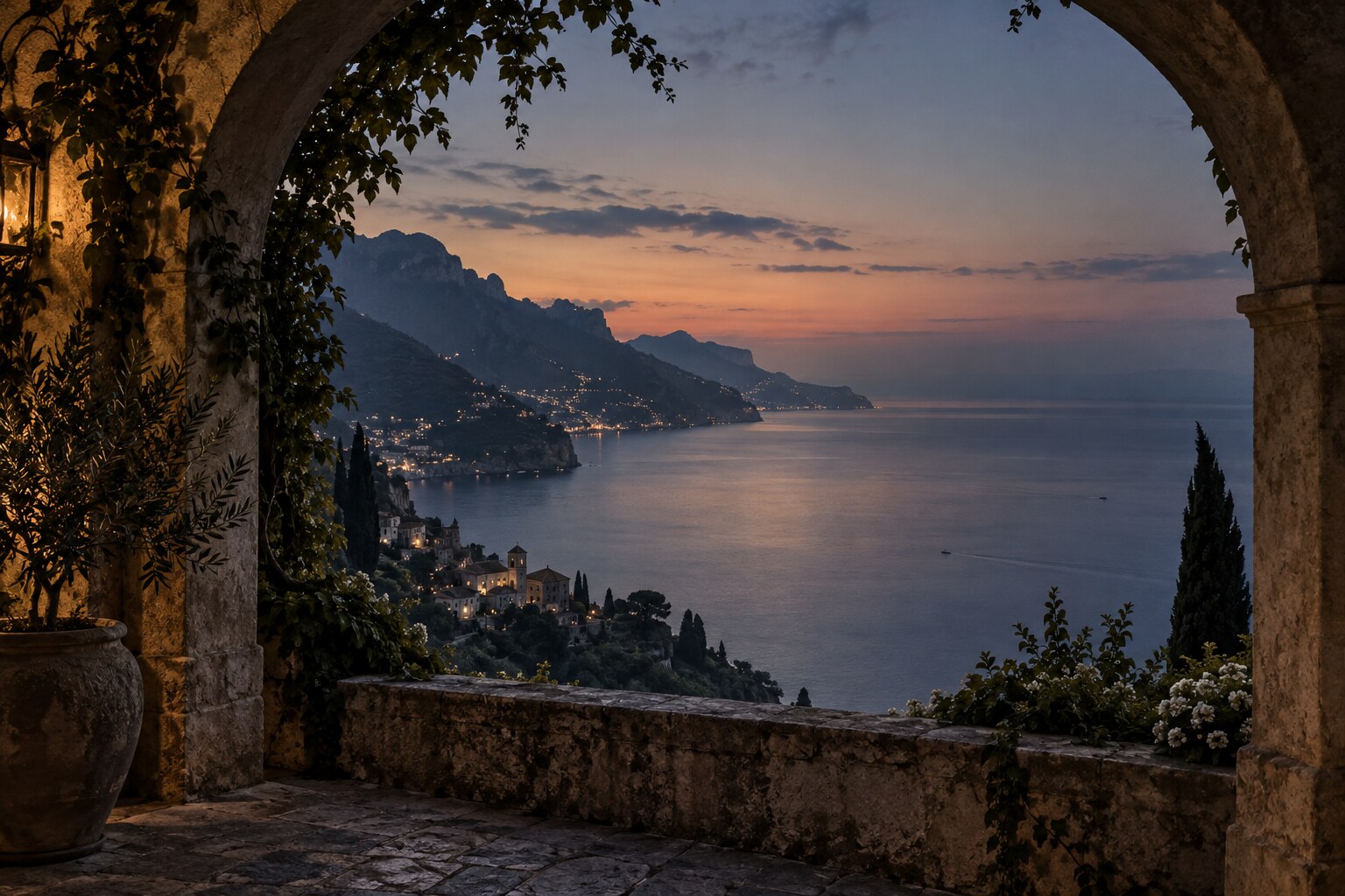 The Amalfi Coast viewed through a stone arch at blue hour